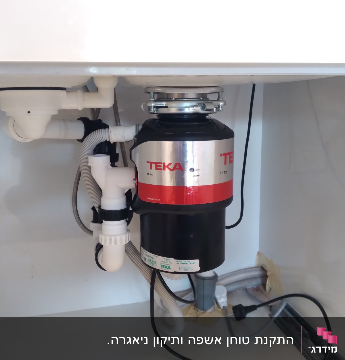 מטחנת אשפה מותקנת מתחת לכיור עם צינורות חיבור